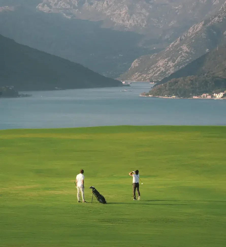 Golfers playing above Boka Bay at Luštica Bay golf course
